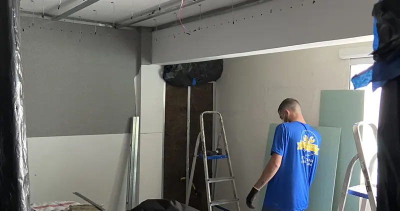 Profissional da FR Soluções fixando placa de gesso acartonado em parede de drywall