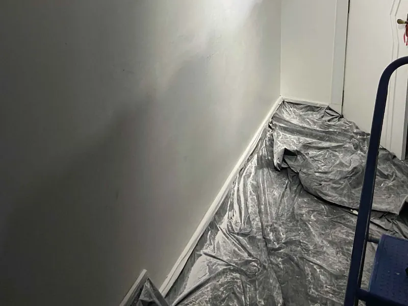 Piso coberto com lona plástica e rodapé protegido antes do início da pintura
